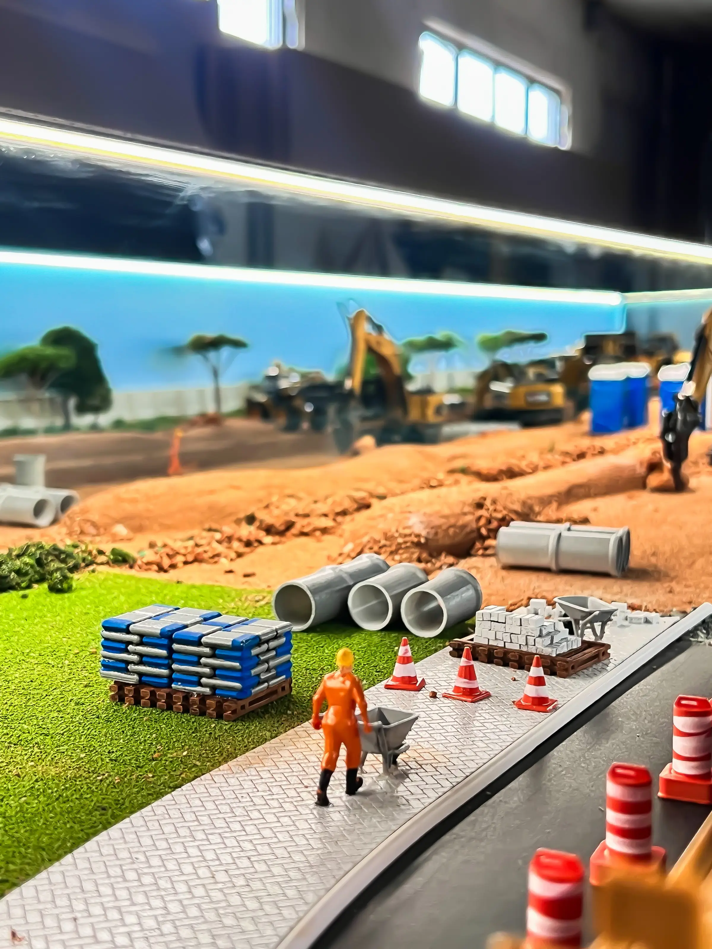 Maquete industrial com maquinário e figuras em escala