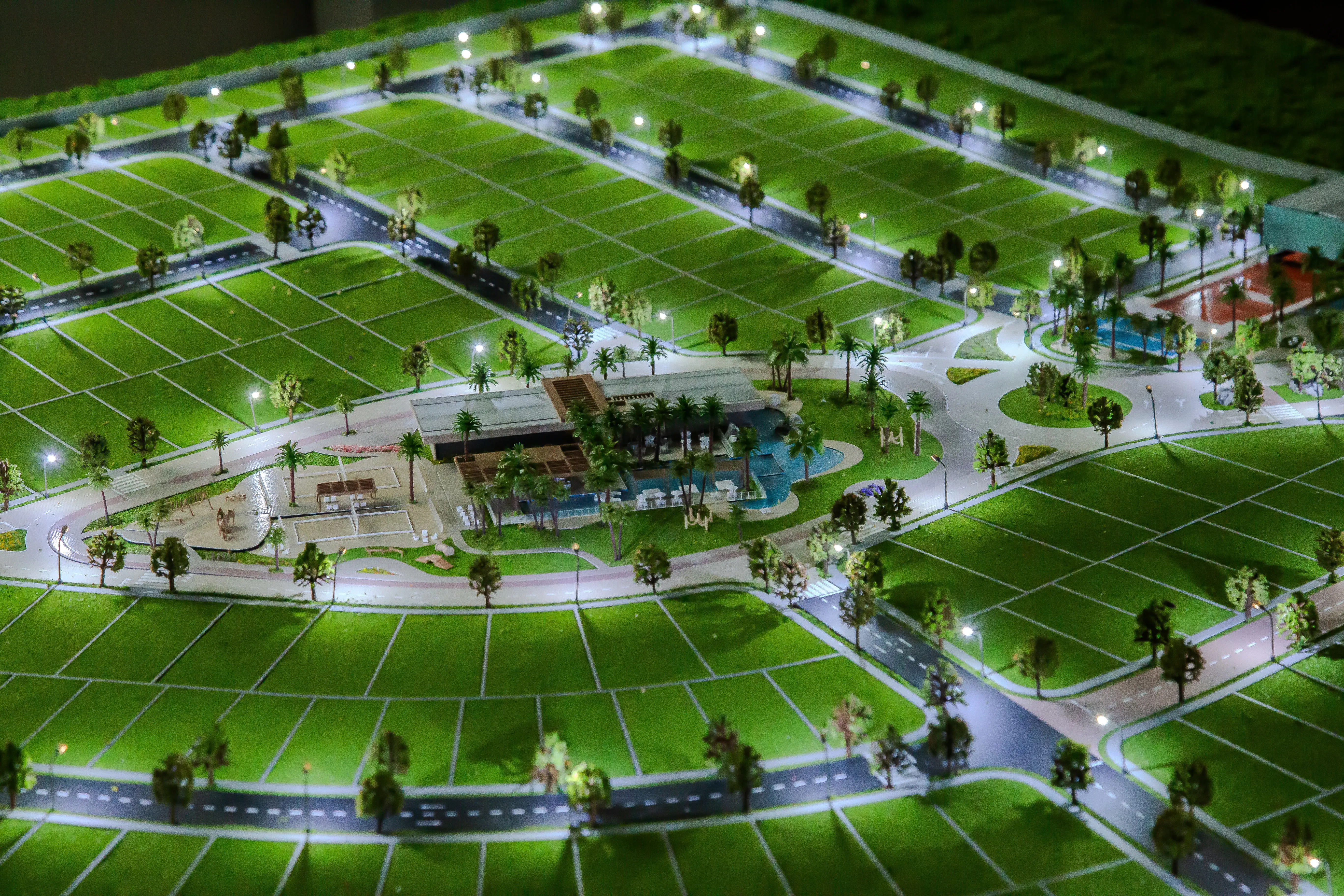 Maquete de loteamento com vias, praças e paisagismo, vista aérea